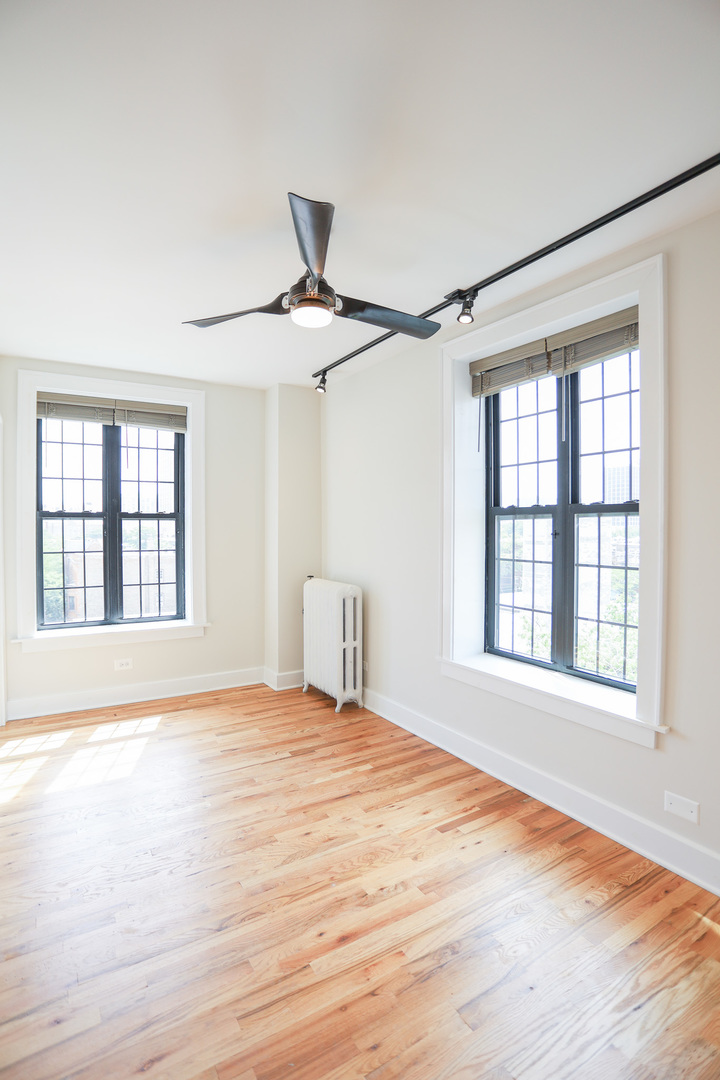 4526 North Sheridan Road, Unit 303 Chicago, IL 60640 - Photo 2 of 14 a view of an empty room with a window and wooden floor