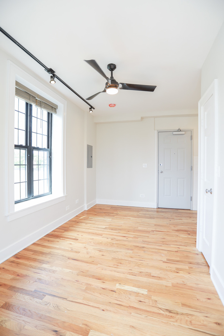 4526 North Sheridan Road, Unit 303 Chicago, IL 60640 - Photo 3 of 14 a view of an empty room with wooden floor and a window