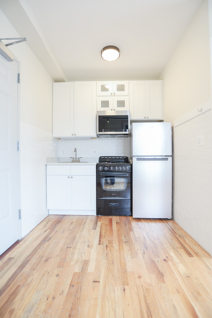 4526 North Sheridan Road, Unit 303 Chicago, IL 60640 - Photo 4 of 14 a kitchen with a refrigerator sink and cabinets