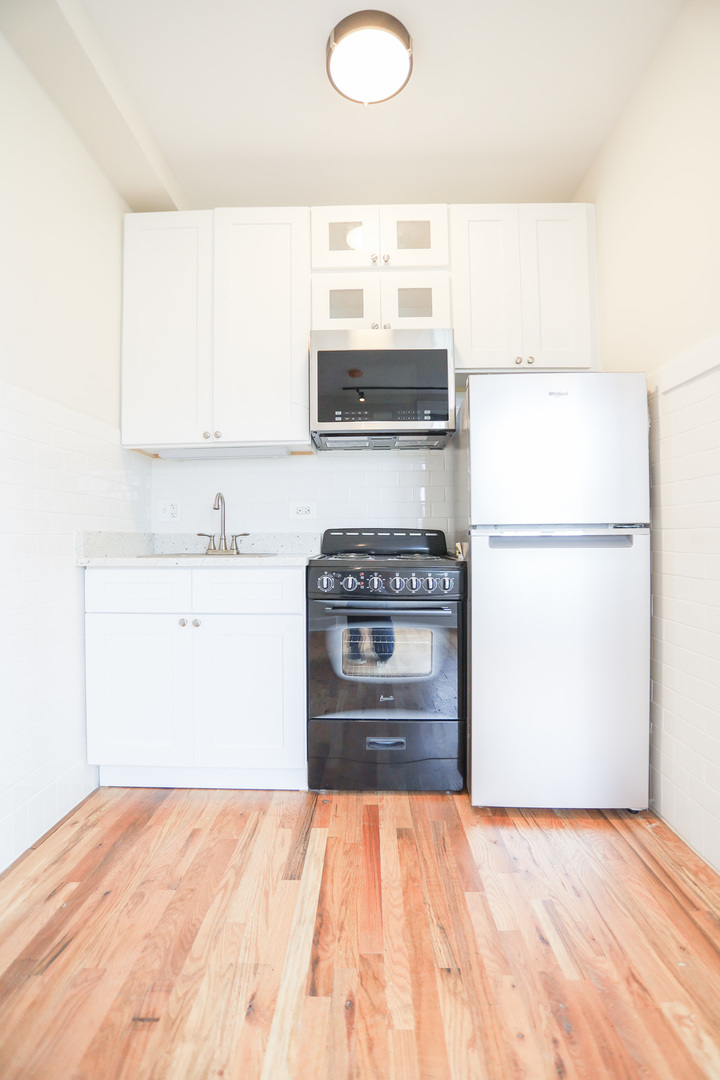 4526 North Sheridan Road, Unit 303 Chicago, IL 60640 - Photo 5 of 14 a kitchen with a stove a refrigerator and a sink