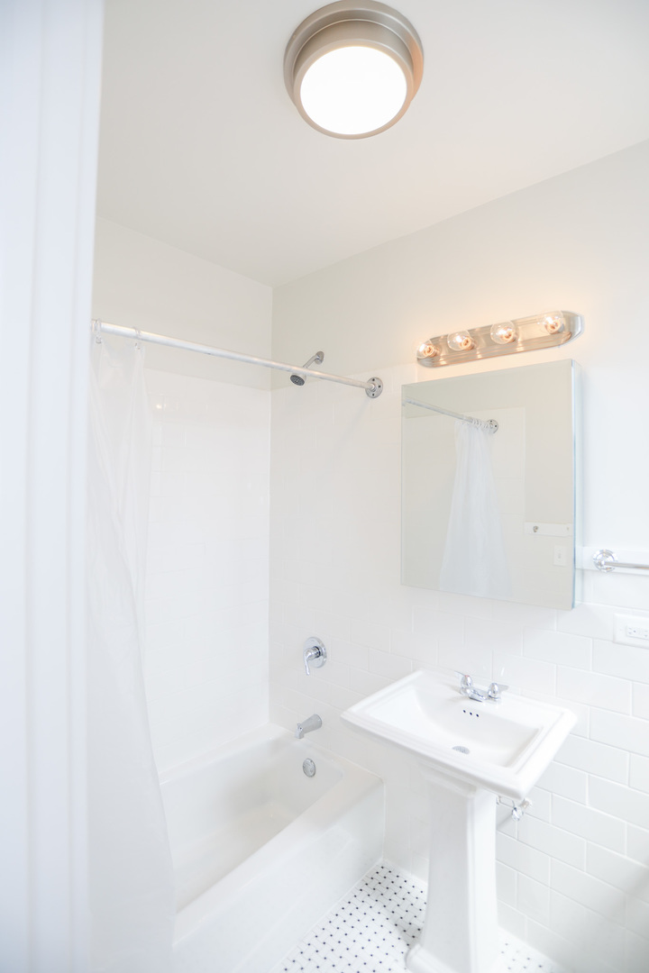 4526 North Sheridan Road, Unit 303 Chicago, IL 60640 - Photo 6 of 14 a bathroom with a sink a toilet and a mirror