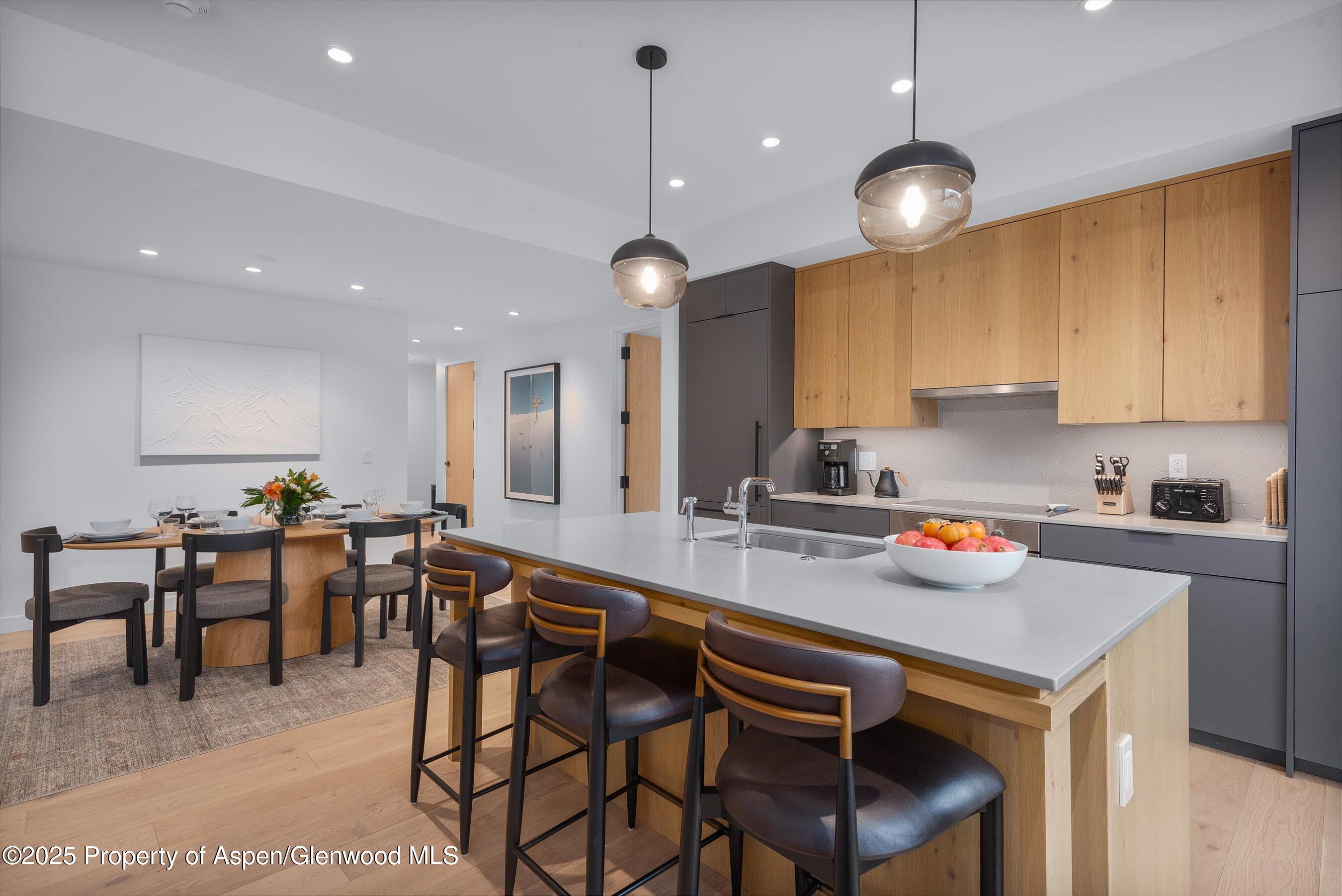 119 Wood Road, Unit 101 Snowmass Village, CO 81615 - Photo 13 of 34 a kitchen with a dining table chairs sink and cabinets