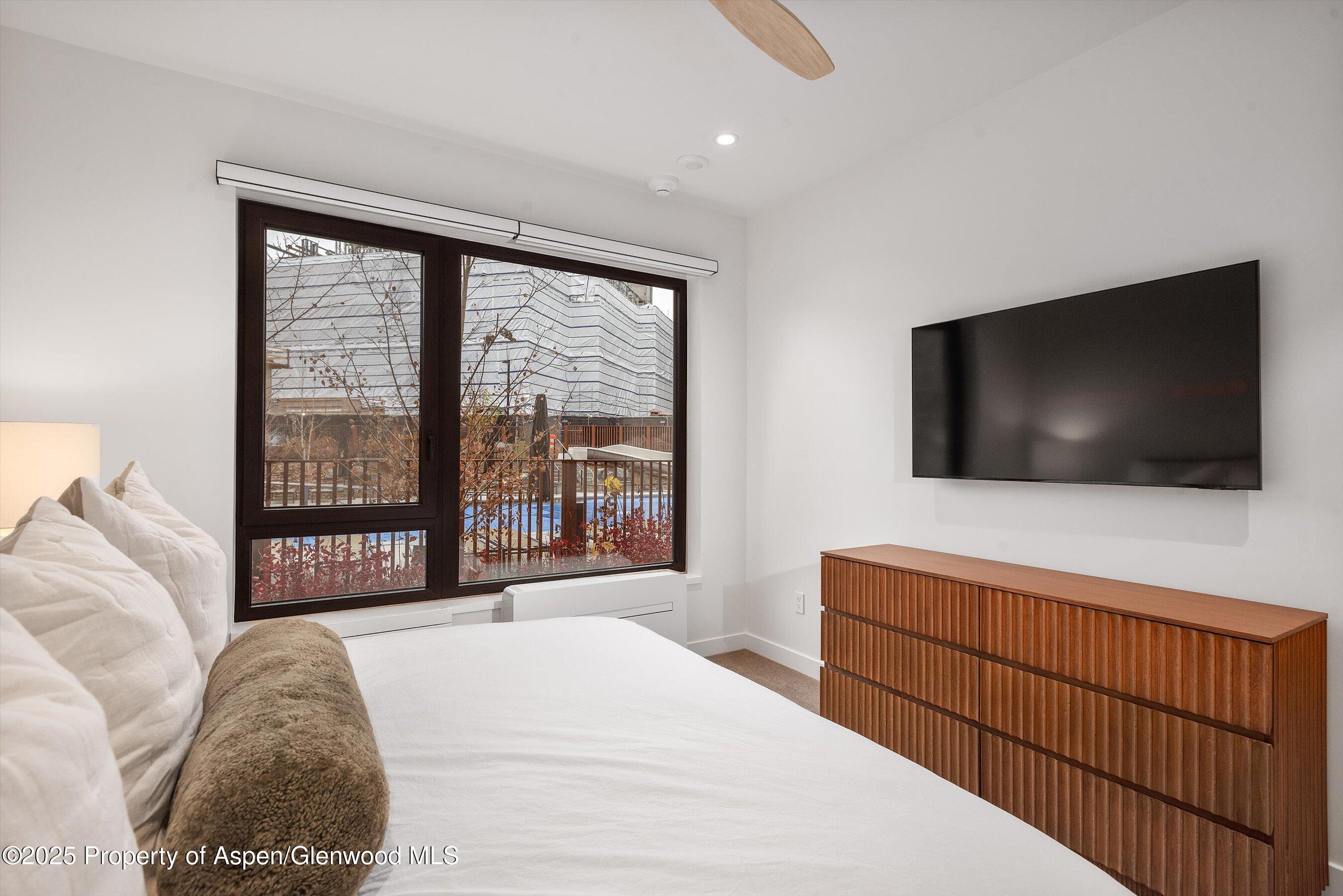 119 Wood Road, Unit 101 Snowmass Village, CO 81615 - Photo 15 of 34 a bedroom with a bed and a flat screen tv