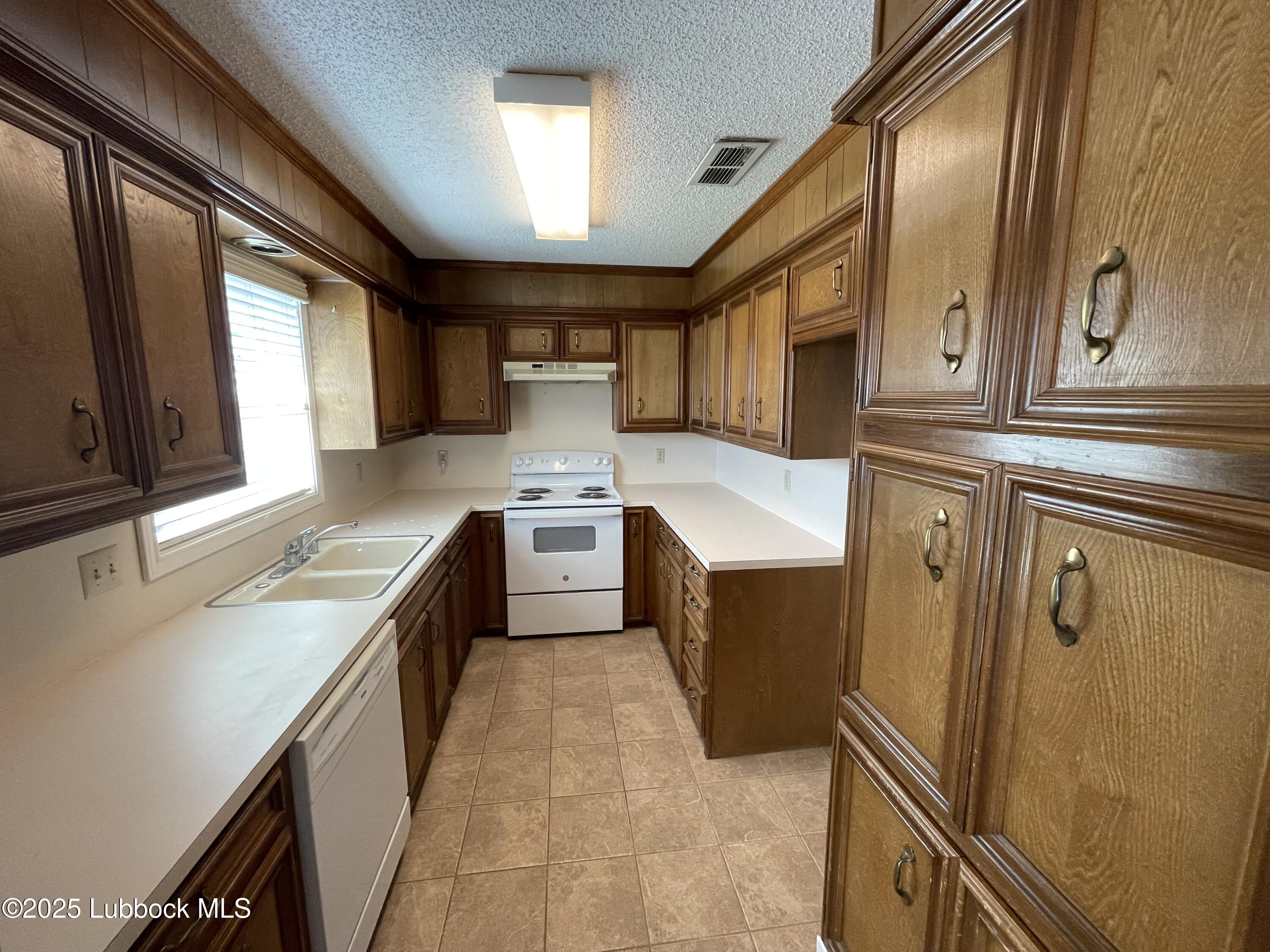 6619 Huron Avenue Lubbock, TX 79424 - Photo 4 of 10 a kitchen with stainless steel appliances granite countertop a sink a stove and a refrigerator