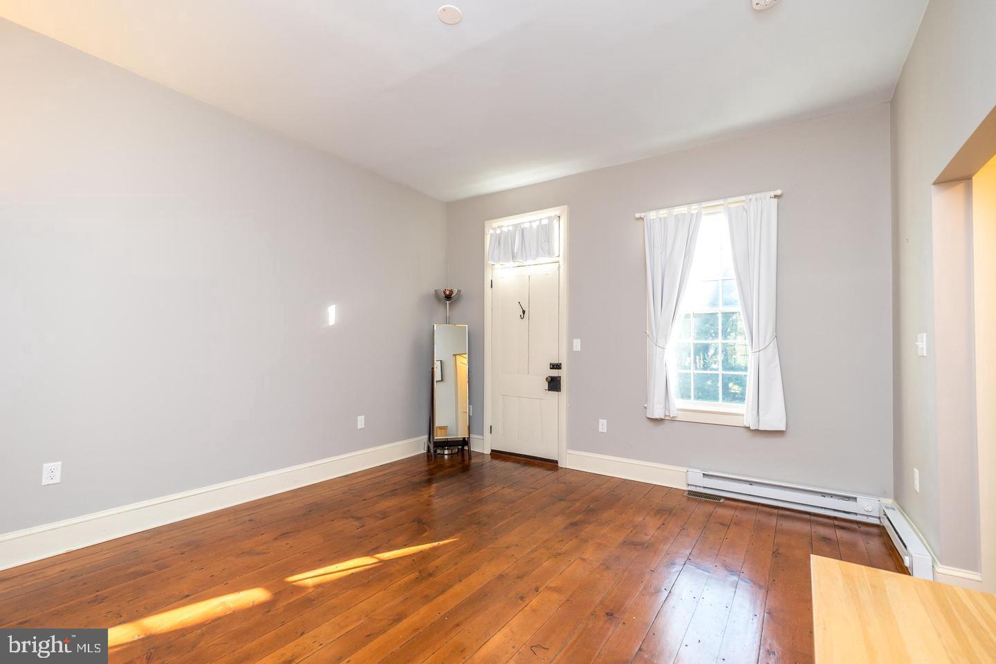 4936 Curly Hill Road Doylestown, PA 18902 - Photo 42 of 102 an empty room with wooden floor and windows