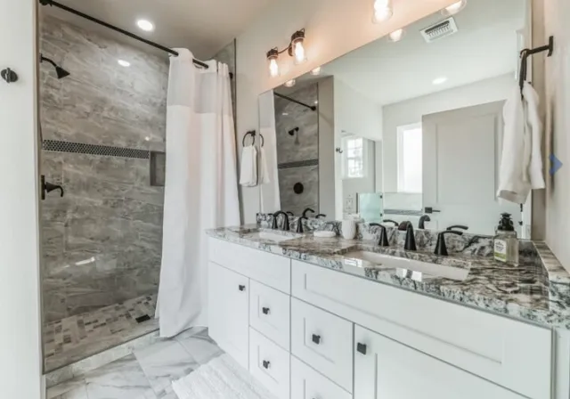 a bathroom with a shower sink and mirror
