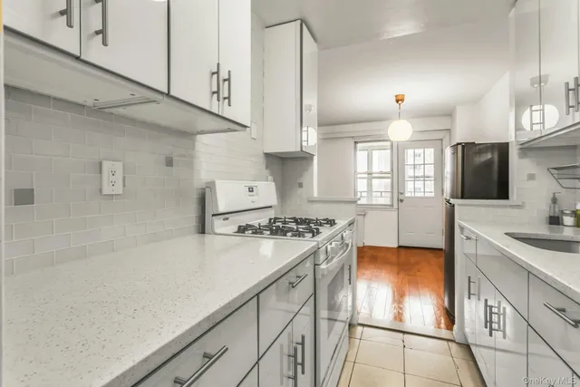 a kitchen with stainless steel appliances granite countertop a sink a stove and a refrigerator