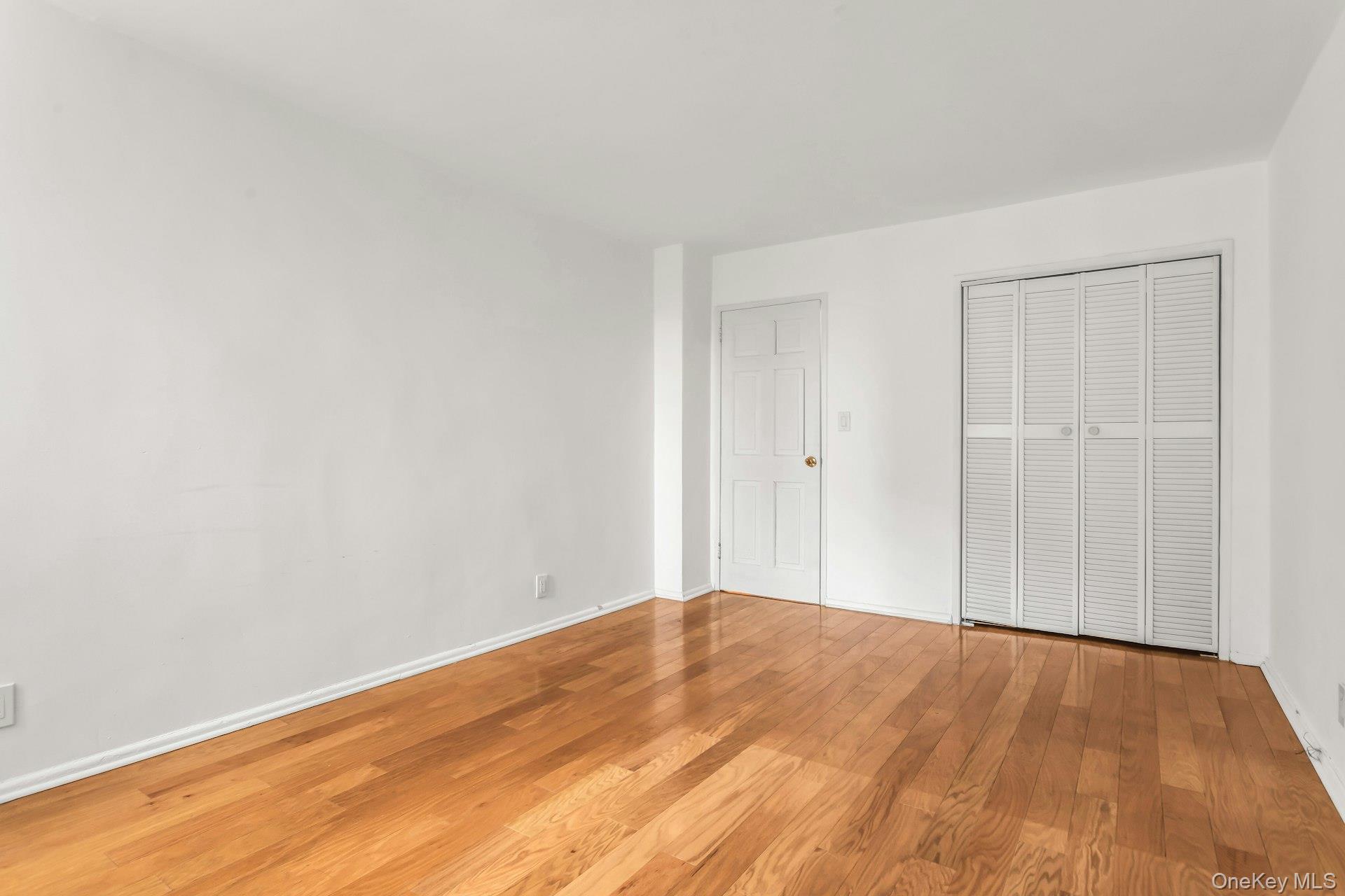 138-10 Franklin Avenue, Unit 9J Queens, NY 11355 - Photo 19 of 25 Unfurnished bedroom with wood-type flooring and a closet