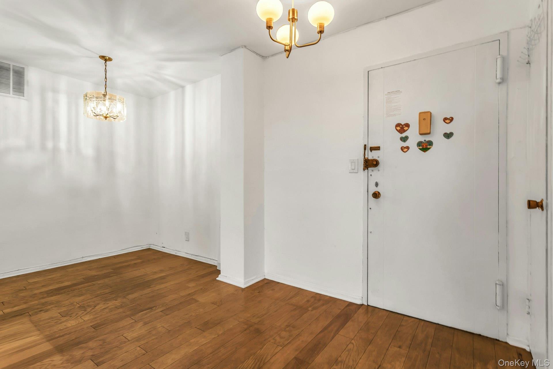 138-10 Franklin Avenue, Unit 9J Queens, NY 11355 - Photo 5 of 25 Entryway with a chandelier and dark wood-style floors