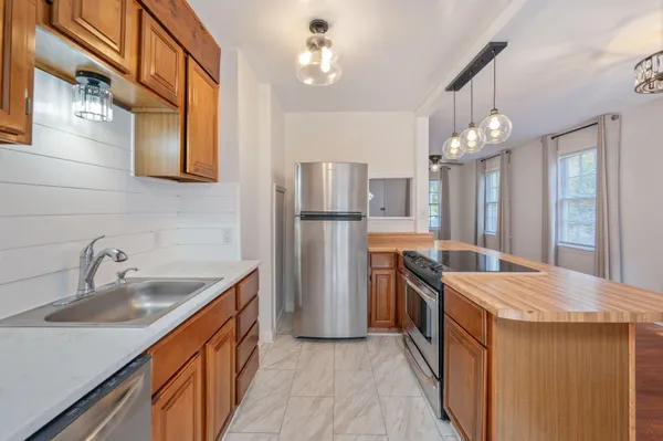 a kitchen with stainless steel appliances granite countertop a sink and refrigerator