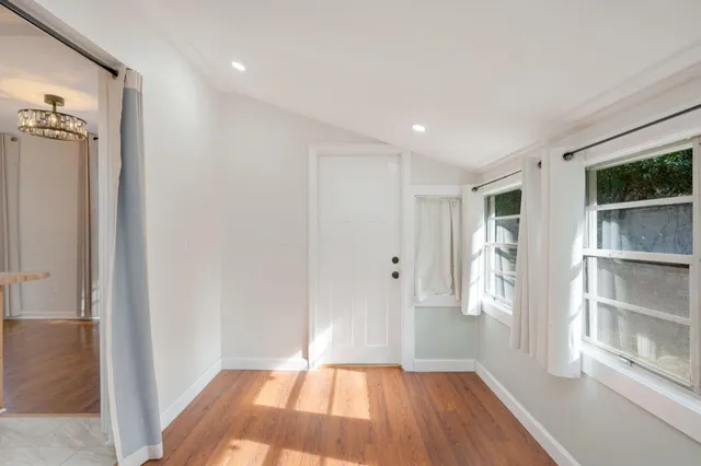a view of a hallway with wooden floor and closet