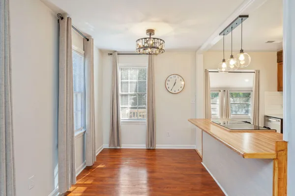 a view of a hallway with wooden floor and chandelier