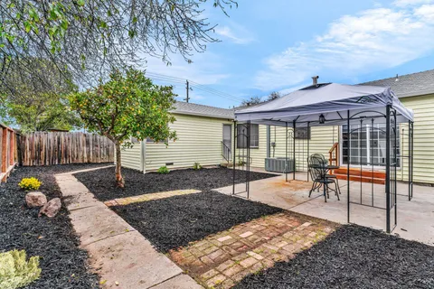 a view of a backyard with a patio and a garden