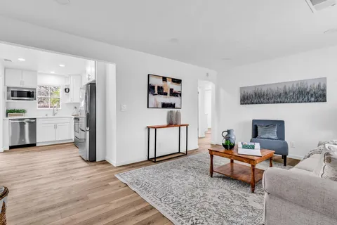 a living room with furniture and a kitchen view