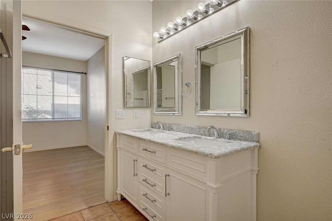 9050 West Warm Springs Road, Unit 1147 Las Vegas, NV 89148 - Photo 28 of 36 Double vanity with elegant marble counters and ample storage in a well-appointed bathroom.