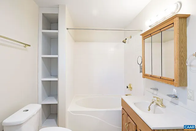 a bathroom with a bathtub sink vanity and toilet