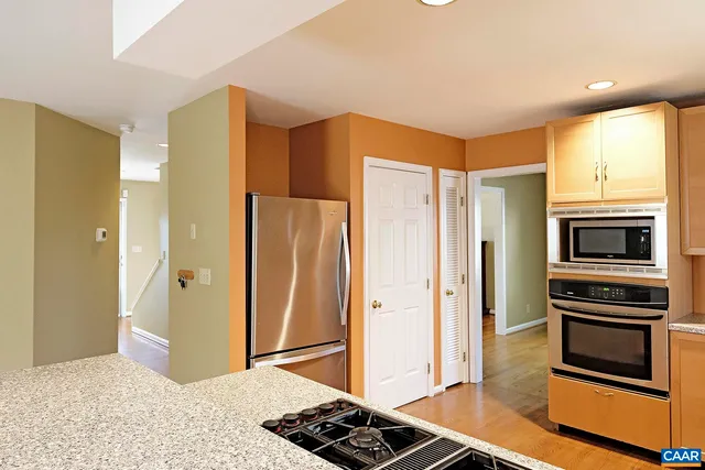 a kitchen with stainless steel appliances granite countertop a refrigerator and a stove top oven