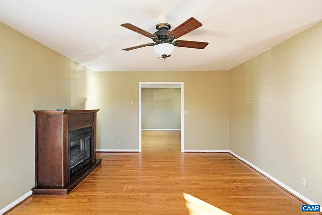 a view of a livingroom with a ceiling fan & wooden floor