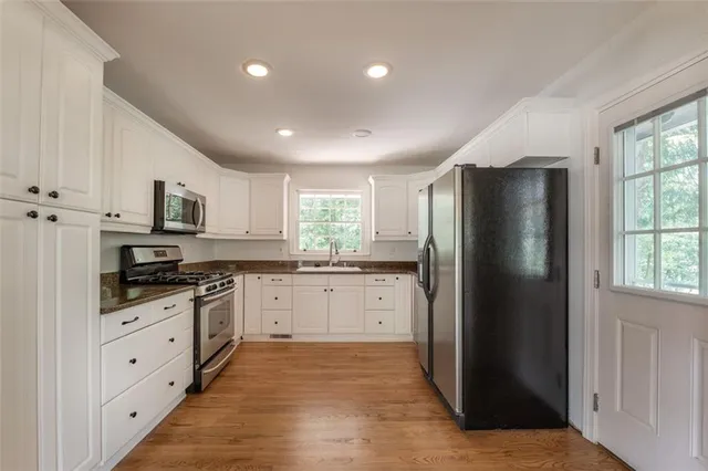 a kitchen with stainless steel appliances granite countertop a refrigerator and a stove top oven
