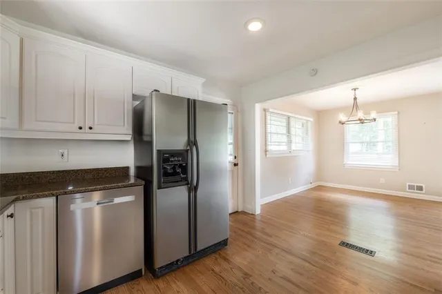 a kitchen with stainless steel appliances white cabinets and a stove top oven