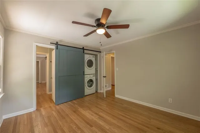 a view of empty room with wooden floor and ceiling fan