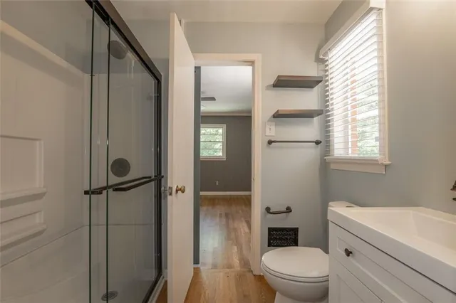 a bathroom with a granite countertop toilet a sink and shower