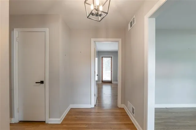 a view of a hallway with wooden floor and closet