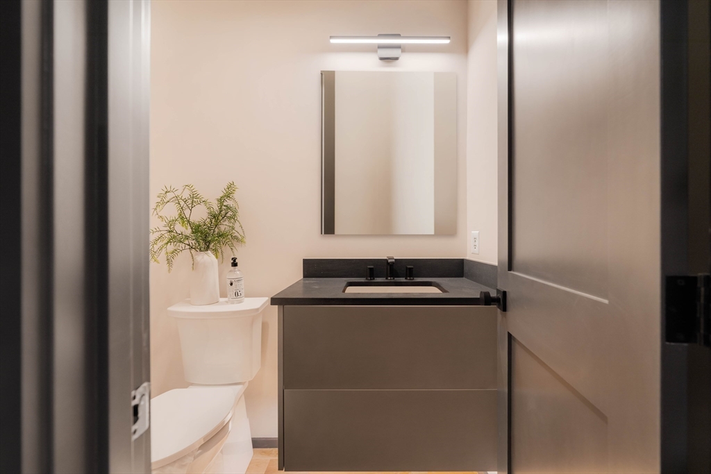 31 Highland Road, Unit 1 Brookline, MA 02445 - Photo 23 of 34 a bathroom with a granite countertop sink and a mirror