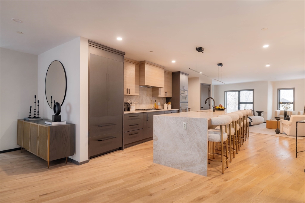 31 Highland Road, Unit 1 Brookline, MA 02445 - Photo 4 of 34 a living room with kitchen island furniture and a kitchen view