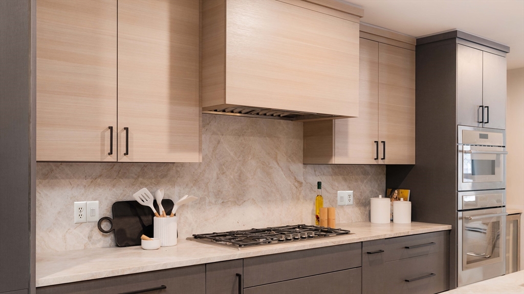 31 Highland Road, Unit 1 Brookline, MA 02445 - Photo 5 of 34 a kitchen with kitchen island a stove a sink and cabinets