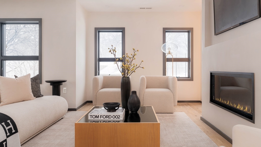 31 Highland Road, Unit 1 Brookline, MA 02445 - Photo 10 of 34 a living room with furniture a large window and a flat screen tv