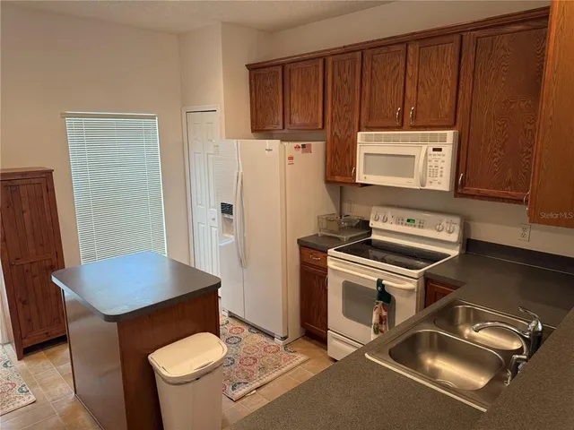 a kitchen with stainless steel appliances a stove a refrigerator island and a refrigerator