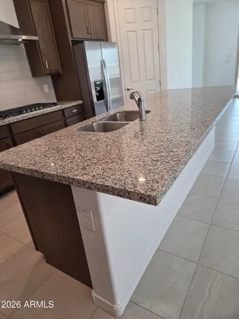 a kitchen with granite countertop a sink and a stove top oven
