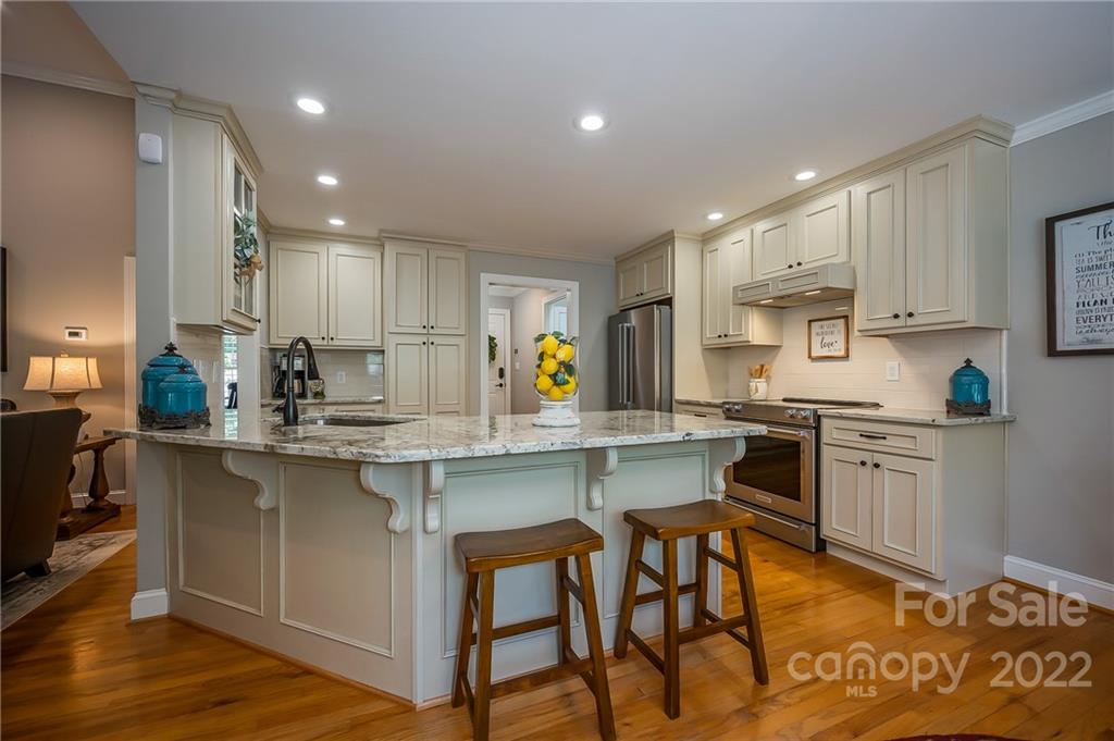 212 Ridgeview Drive Rutherfordton, NC 28139 - Photo 12 of 47 a kitchen with stainless steel appliances granite countertop a stove top oven a sink dishwasher and white cabinets with wooden floor