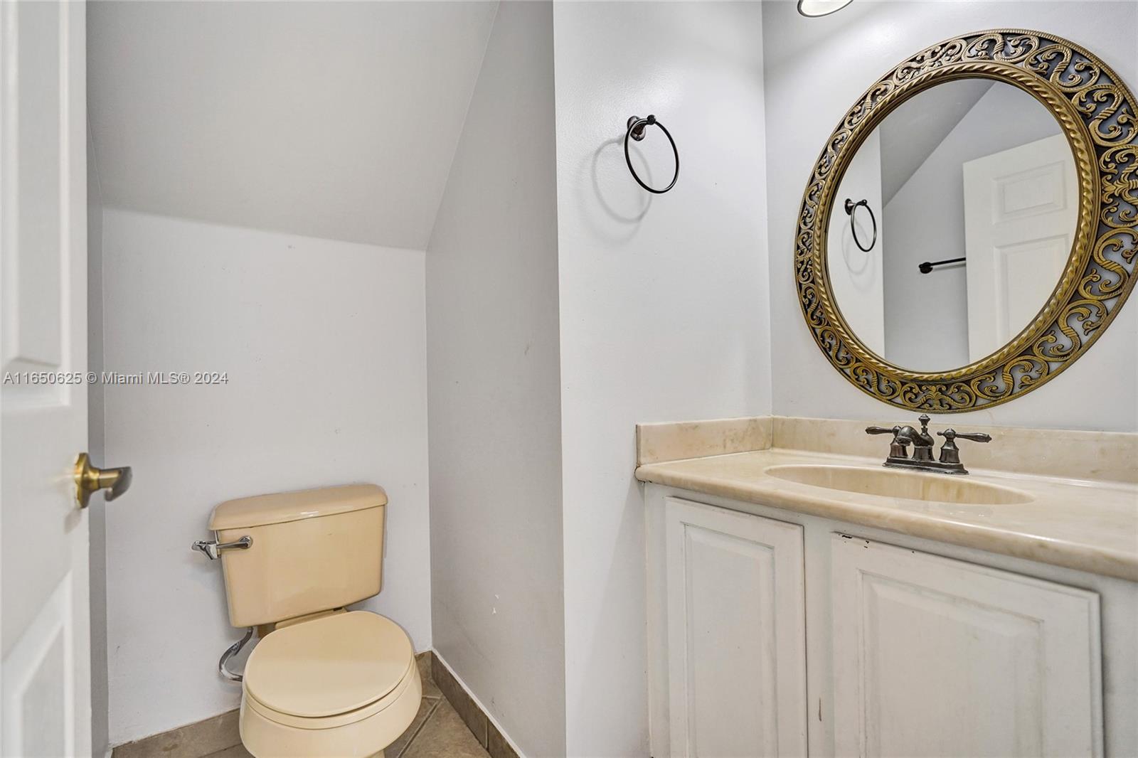 6073 Spring Isles Boulevard Lake Worth, FL 33463 - Photo 21 of 66 a bathroom with a toilet a sink and a mirror