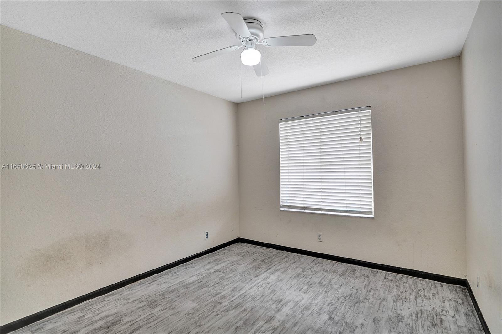 6073 Spring Isles Boulevard Lake Worth, FL 33463 - Photo 27 of 66 an empty room with a window and ceiling fan