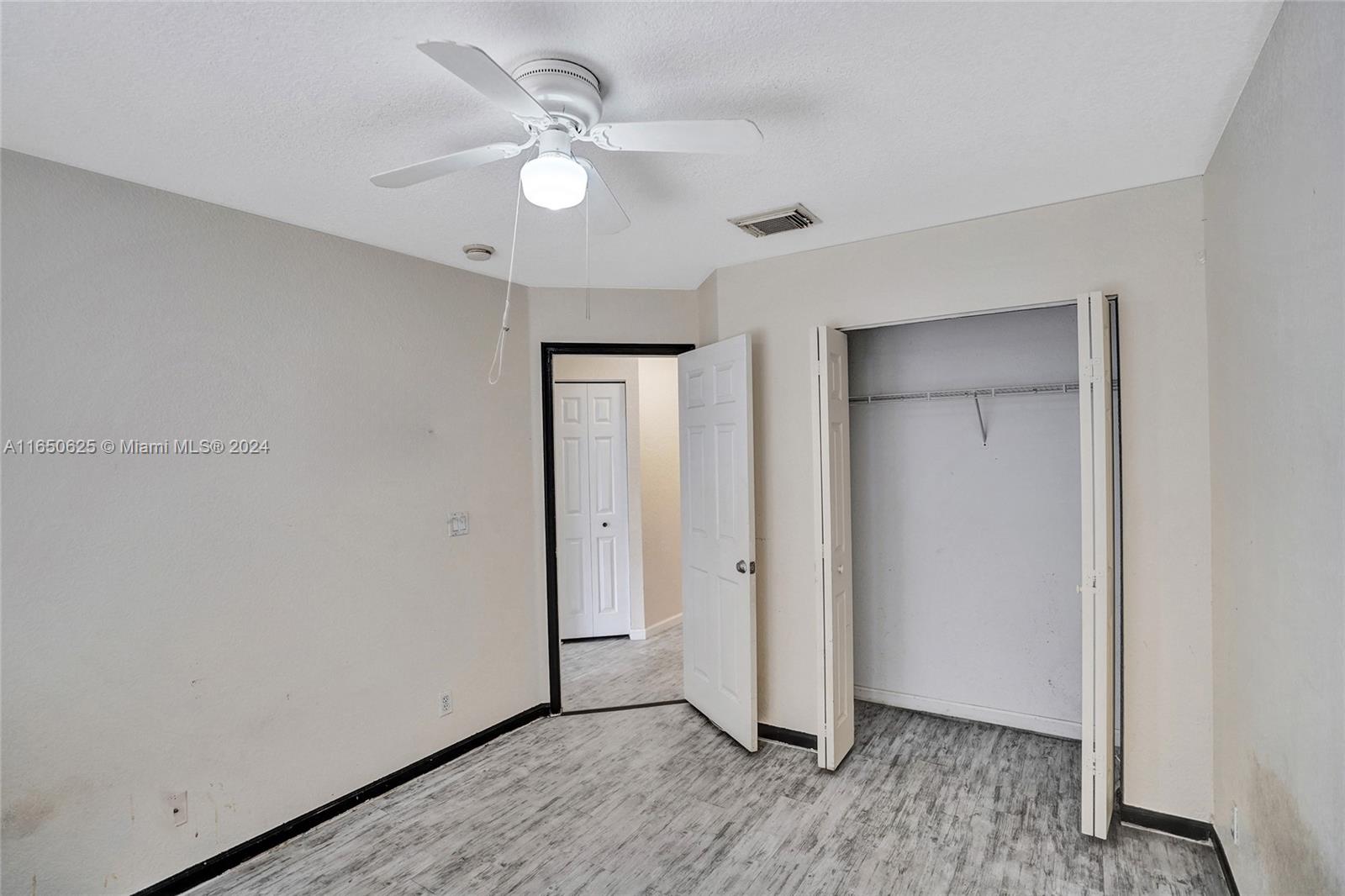 6073 Spring Isles Boulevard Lake Worth, FL 33463 - Photo 28 of 66 an empty room with wooden floor and window