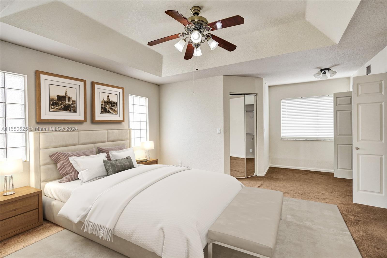 6073 Spring Isles Boulevard Lake Worth, FL 33463 - Photo 35 of 66 a bedroom with a large bed and a chandelier