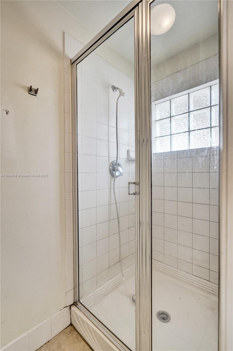 6073 Spring Isles Boulevard Lake Worth, FL 33463 - Photo 39 of 66 a bathroom with a glass shower door