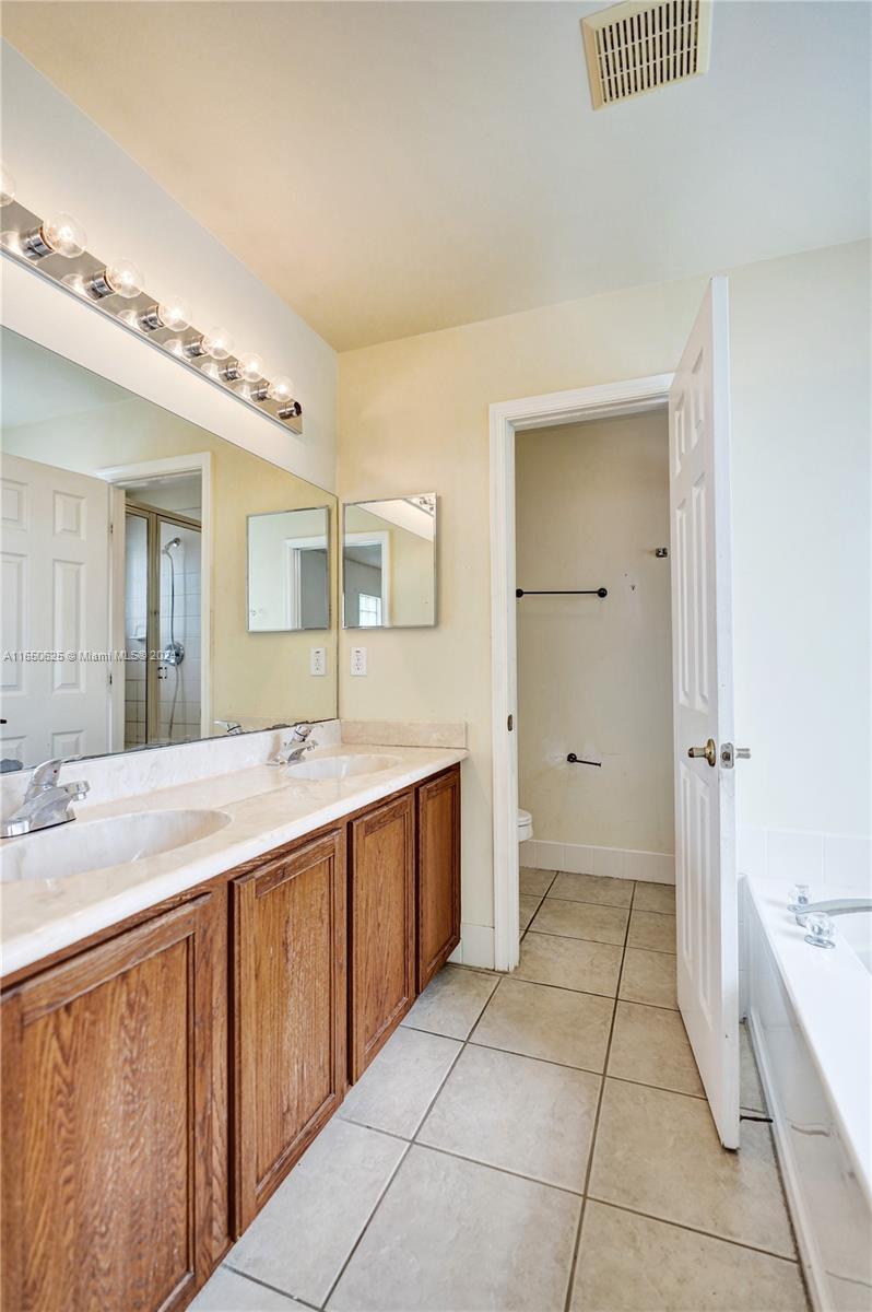 6073 Spring Isles Boulevard Lake Worth, FL 33463 - Photo 41 of 66 a spacious bathroom with a granite countertop sink a mirror and a bathtub
