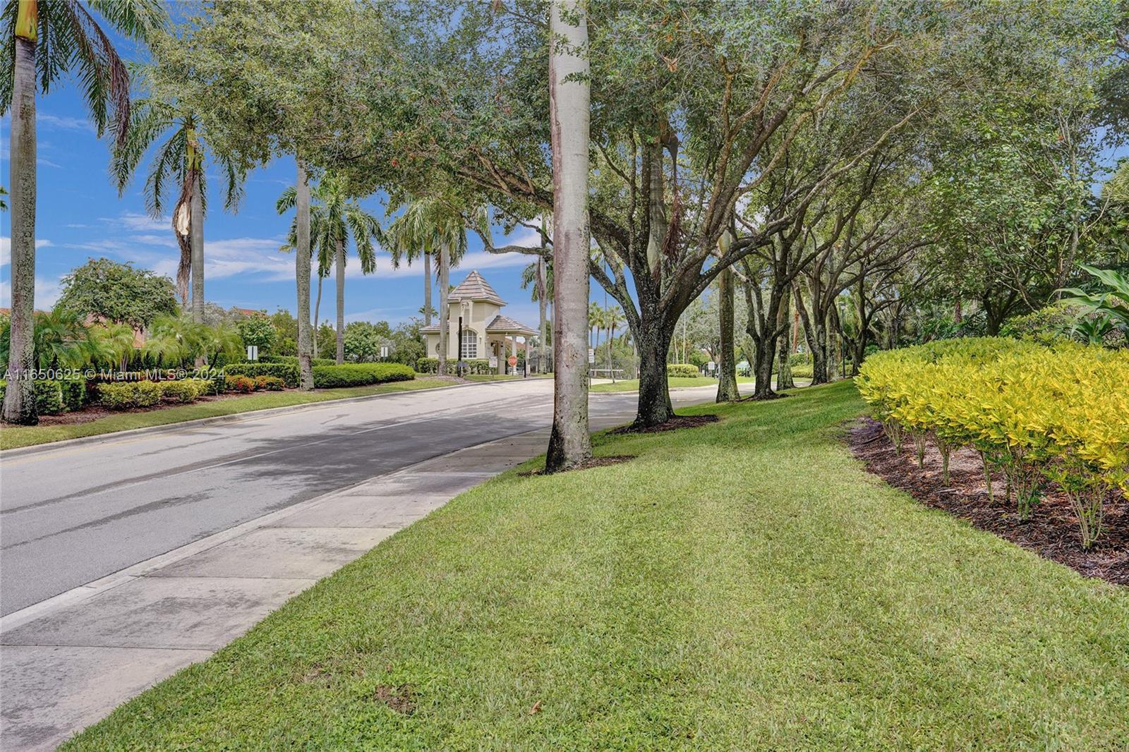 6073 Spring Isles Boulevard Lake Worth, FL 33463 - Photo 51 of 66 a view of a street with a building and trees in the background