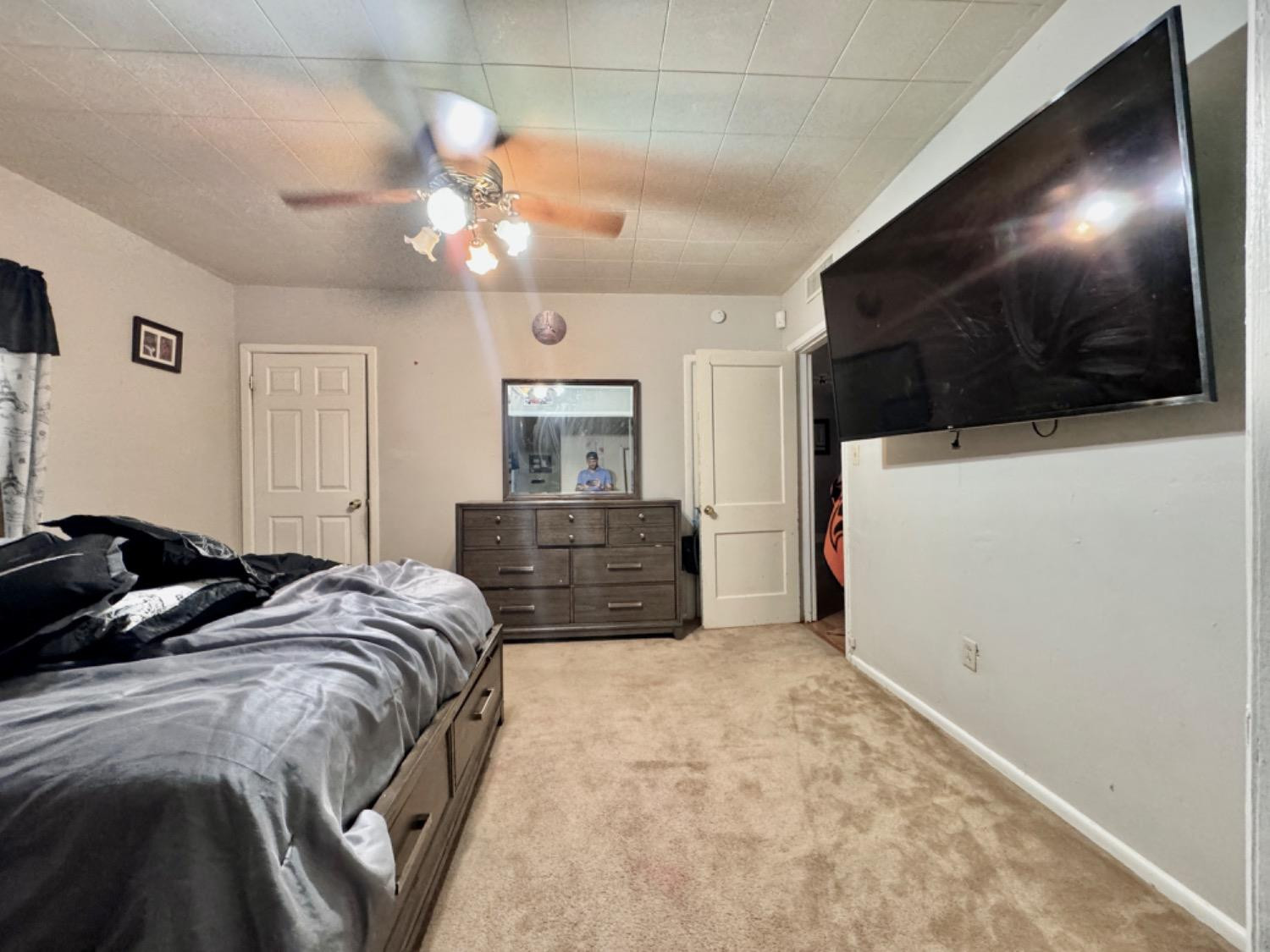 1901 28th Street Lubbock, TX 79411 - Photo 13 of 17 a bed room with a bed a television and a potted plant