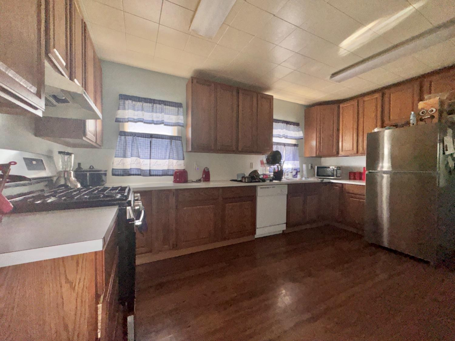 1901 28th Street Lubbock, TX 79411 - Photo 7 of 17 a kitchen with granite countertop a refrigerator a sink dishwasher a stove top oven a refrigerator and cabinets