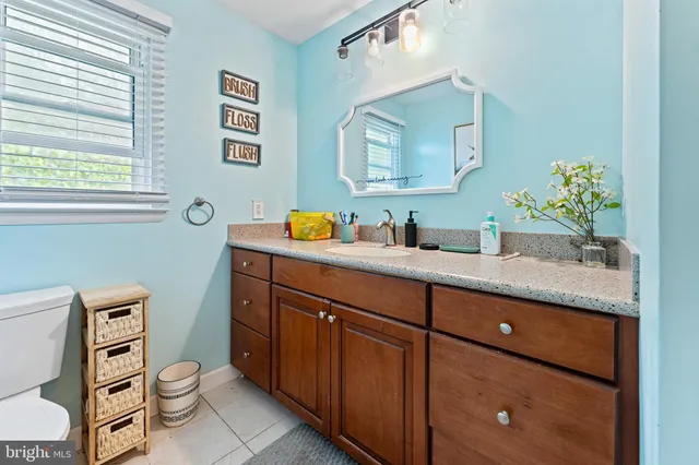a bathroom with a granite countertop toilet sink and mirror