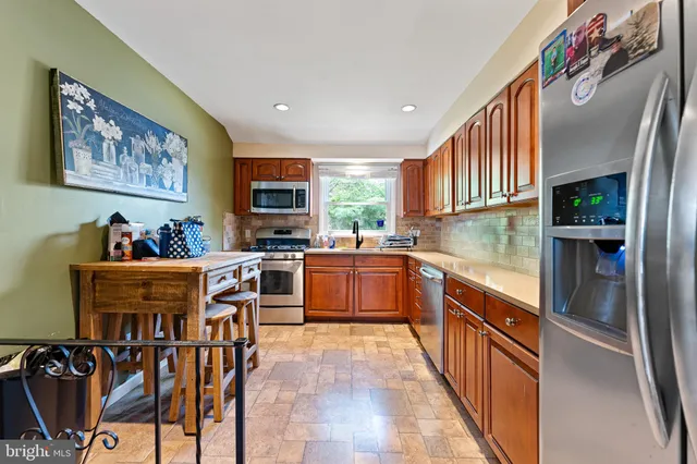 a kitchen with stainless steel appliances a stove a sink and a refrigerator