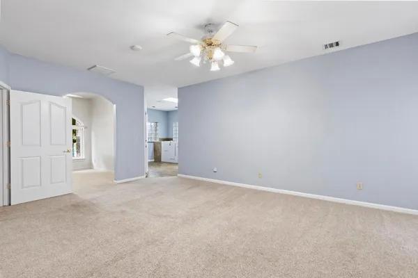 a view of an empty room with window and wooden floor