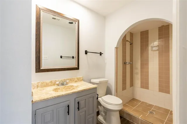 a bathroom with a granite countertop sink toilet and shower