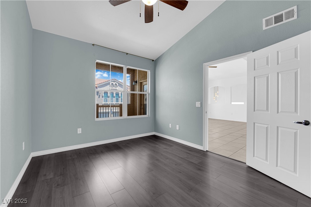 10550 West Alexander Road, Unit 2079 Las Vegas, NV 89129 - Photo 12 of 40 Unfurnished room featuring a ceiling fan, lofted ceiling, dark wood-style flooring, and baseboards
