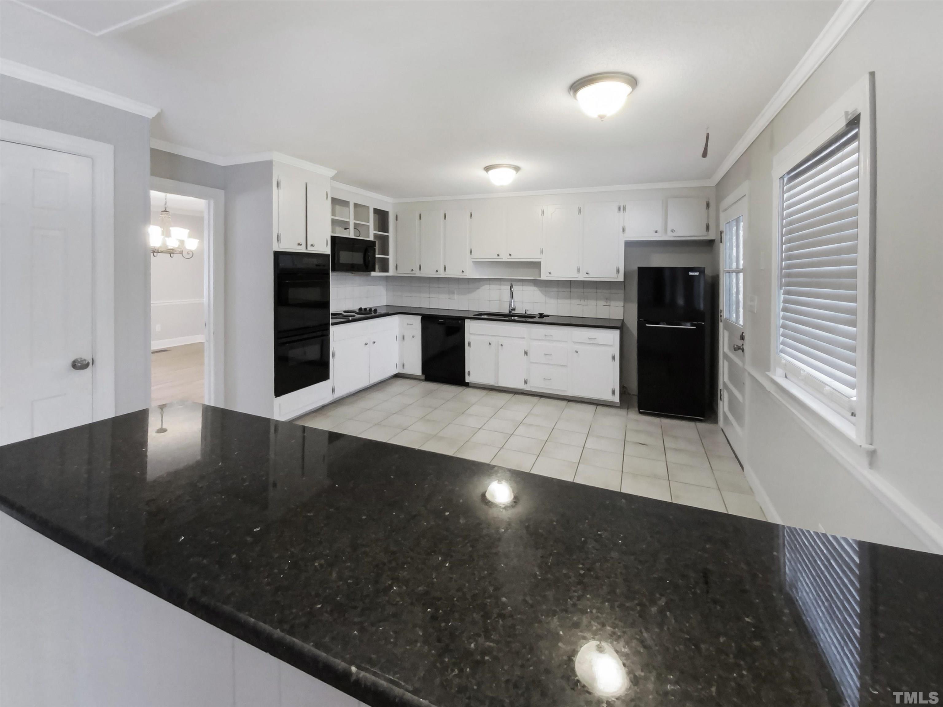 3200 Caldwell Drive Raleigh, NC 27607 - Photo 12 of 19 a large kitchen with stainless steel appliances a large counter top a stove a sink a refrigerator and a granite counter tops