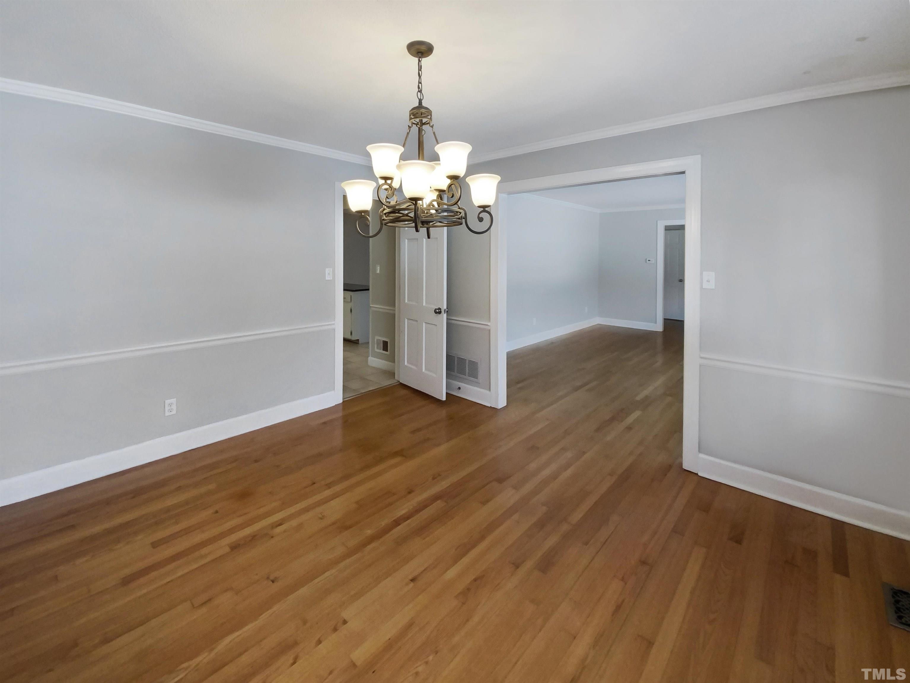 3200 Caldwell Drive Raleigh, NC 27607 - Photo 4 of 19 a view of a room with wooden floor chandelier and entryway